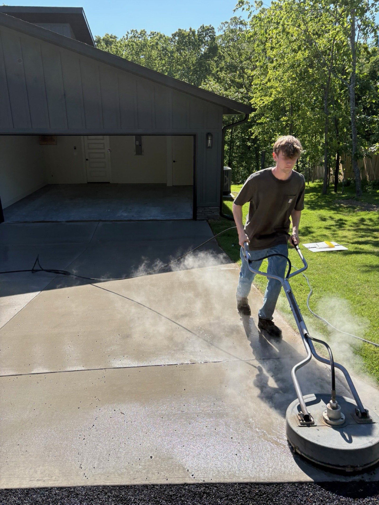 Iron Jet steam-cleaning a new concrete driveway with a hot-water surface cleaner